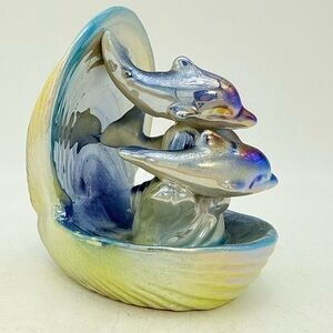 Vintage iridescent ceramic dolphins figures inside a clamshell